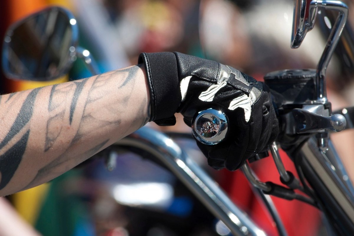 Mano con guante de moto sujetando el manillar